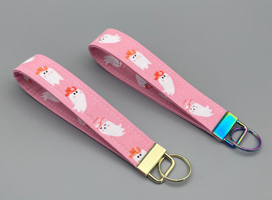 Pink keychain with cartoon characters on a gray background